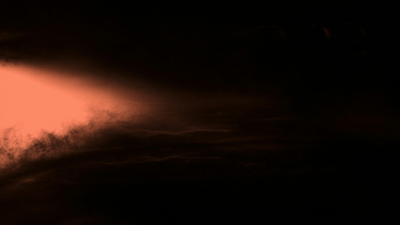 A soft coral beam of light sweeping across a dark surface, like a page being scanned out of shadow.